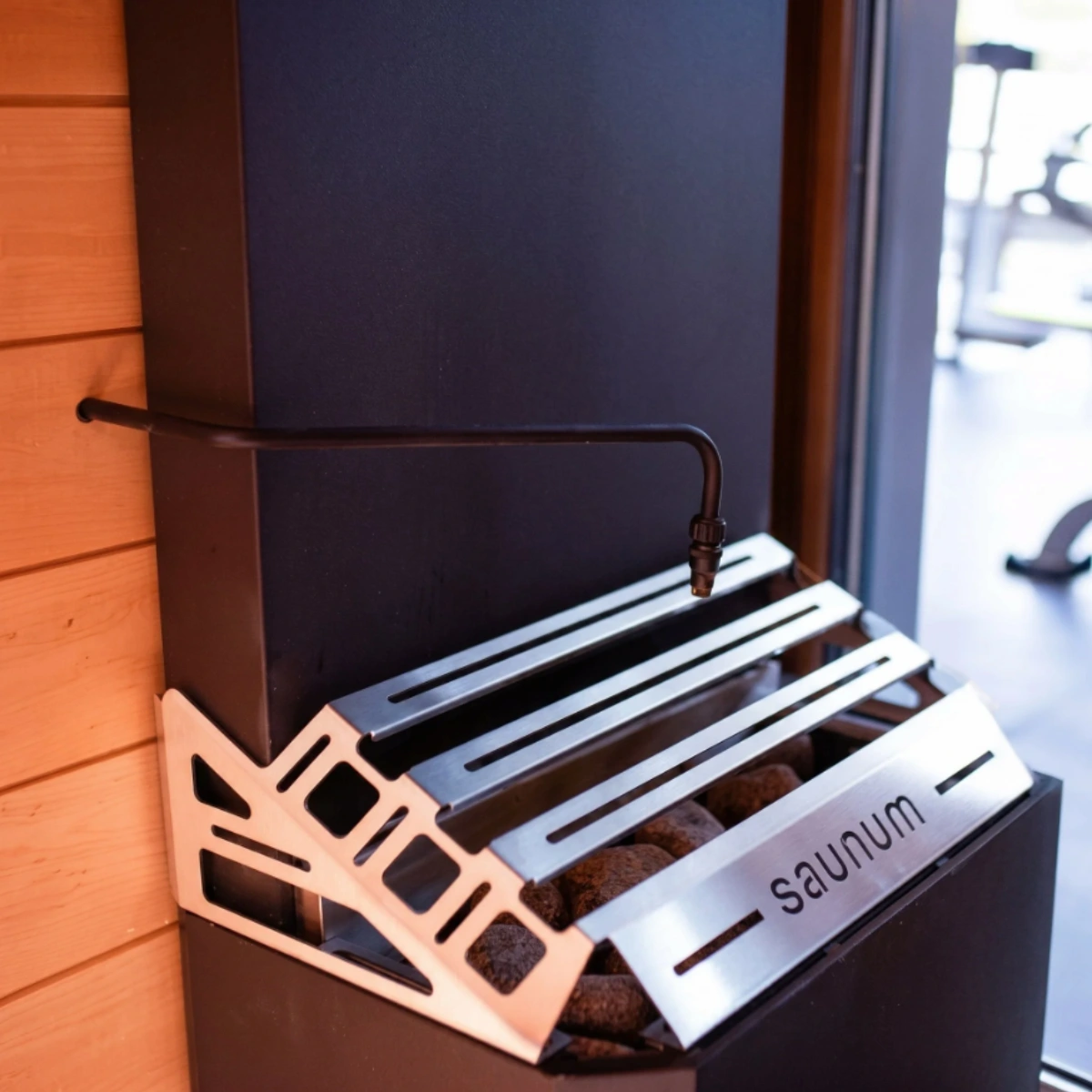 Saunum Auto Leil water dispensing pipe installed above a sauna heater